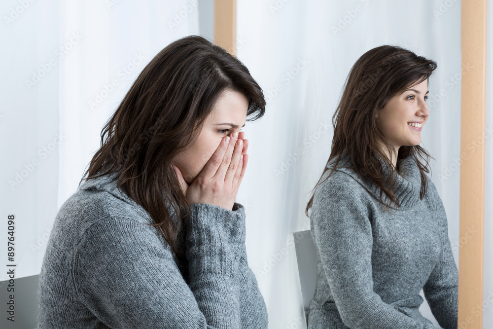 Wall mural Troubled woman trying to smile