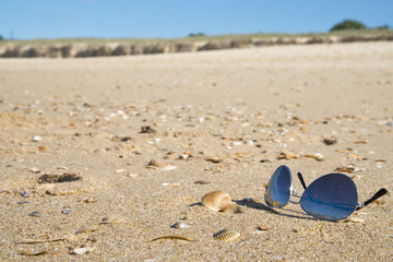 Fototapeta na wymiar Sunglasses on sandy beach