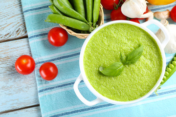 Tasty peas soup and vegetables on table close up