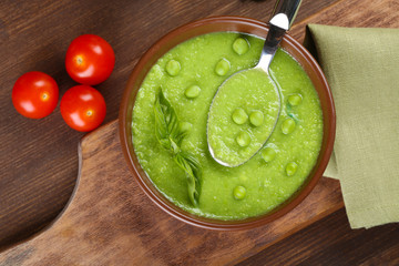 Tasty peas soup and cherry tomatoes on table close up
