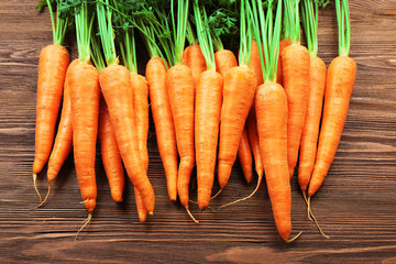 Fresh organic carrots on wooden table, closeup