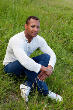Cool handsome guy sitting on the grass