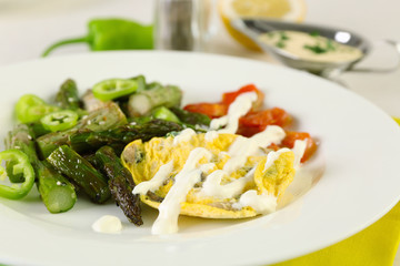 Roasted asparagus with fried egg on plate on table, close-up