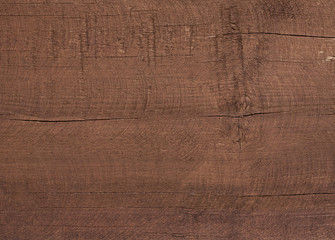 Dark brown scratched wooden cutting board. Wood texture