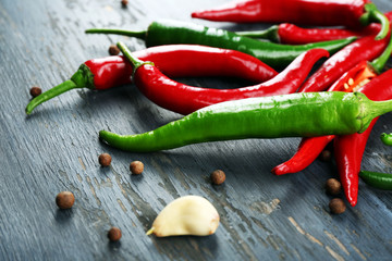 Hot peppers with spices on wooden table close up