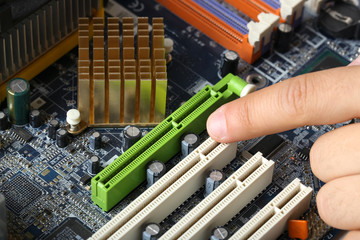 Finger points to motherboard, closeup