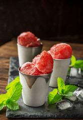 Frozen watermelon balls on a black stone plaque