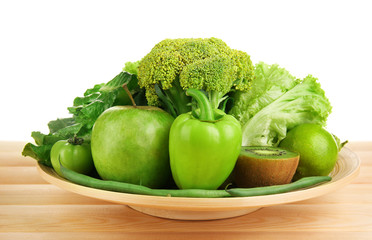 Fresh green food in wooden plate isolated on white