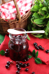 Jar of gooseberry jam on wooden table close-up