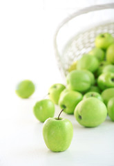 Green apples in wicker basket, closeup
