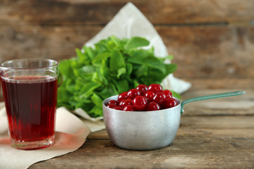 Two glasses with cherry juice on table, on wooden background