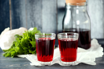 Sweet homemade cherry juice on table, on color wooden background