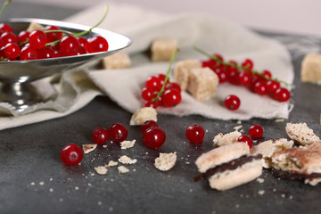 Ripe red currants with lamp sugar on table with sackcloth, closeup