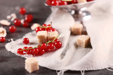 Ripe red currants with lamp sugar on table with sackcloth, closeup