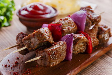 skewers kebab of meat with red sauce on the board