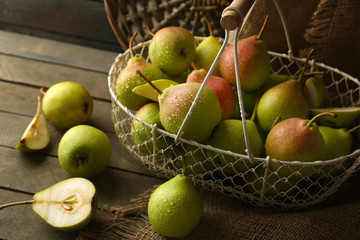 Ripe tasty pears in basket on table close up