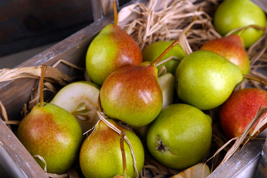 Ripe pears in wooden box close up