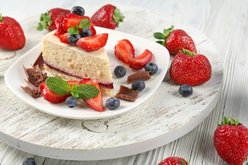 Delicious cheesecake with berries on table close up