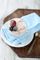 Delicious ice cream with fresh frozen berries, on color wooden background
