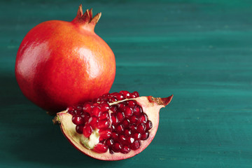 Juicy pomegranate on green wooden background