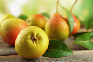 Fresh pears on wooden table on blurred background