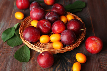Ripe plums on wooden table, closeup