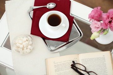 Cup of tea with book on table close up