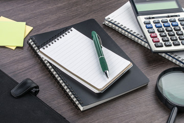 notebook, pen and Magnifier with Calculator on the desk