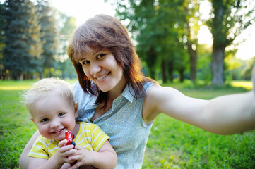 Young woman and her toddler son making selfie