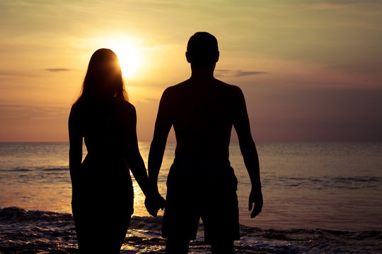 couple in love back light silhouette on sea at the  sunset time