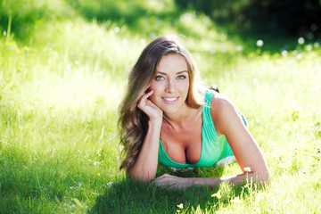 young woman in green dress lying on grass