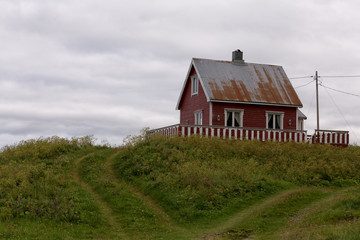 An old house on a hill with heart shaped tracks in front of it
