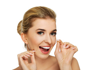 Young woman flossing her teeth.