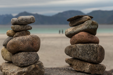 Two piles of pebbles on rock with the ocean in the background