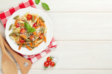 Colorful penne pasta with tomatoes and basil