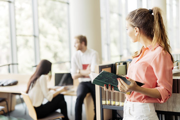 Beautiful woman reading a book in a library