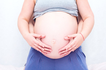 Parents hands on pregnant belly