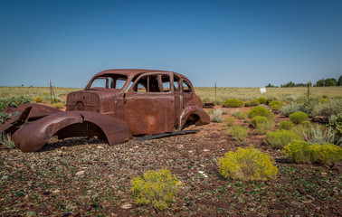 Classic Old Car decays in a meadow. 
