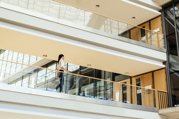 Fototapeta premium Elegant businesswoman walking inside building