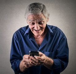 Elderly man sending a text message
