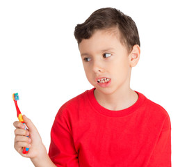 Young boy looking in angry way to his teeth brush
