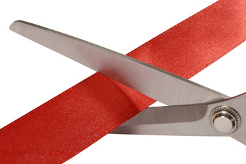 Scissors cutting red ribbon or tape close up isolated on white background photo