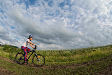 Fototapeta na wymiar young woman riding her bike on a rural trail