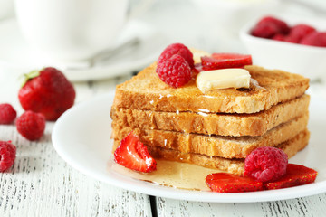 Fresh toast with raspberry and strawberry on white wooden backgr