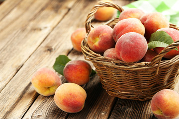 Ripe peaches fruit in basket on a brown wooden background