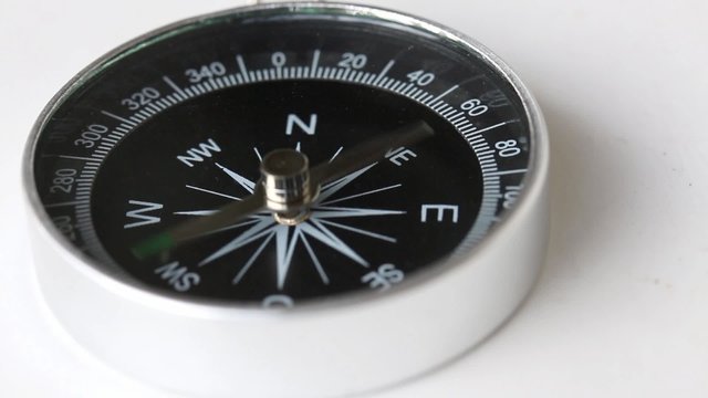 A compass lying on a white table and goes crazy...