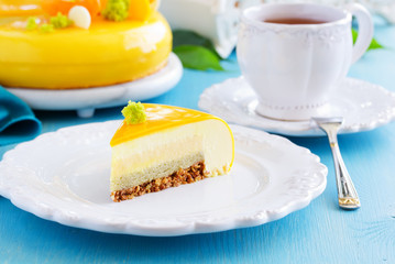 Cake with orange mousse and almond krokantom in the mirror glaze. Selective focus.