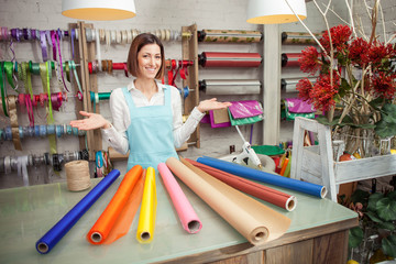 Attractive young female florist is selling in her store