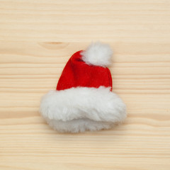 Obraz na płótnie Canvas Red white winter cap - Hat Santa Claus on a wooden surface