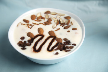 Vanilla yogurt with raisins and almond in a bowl.